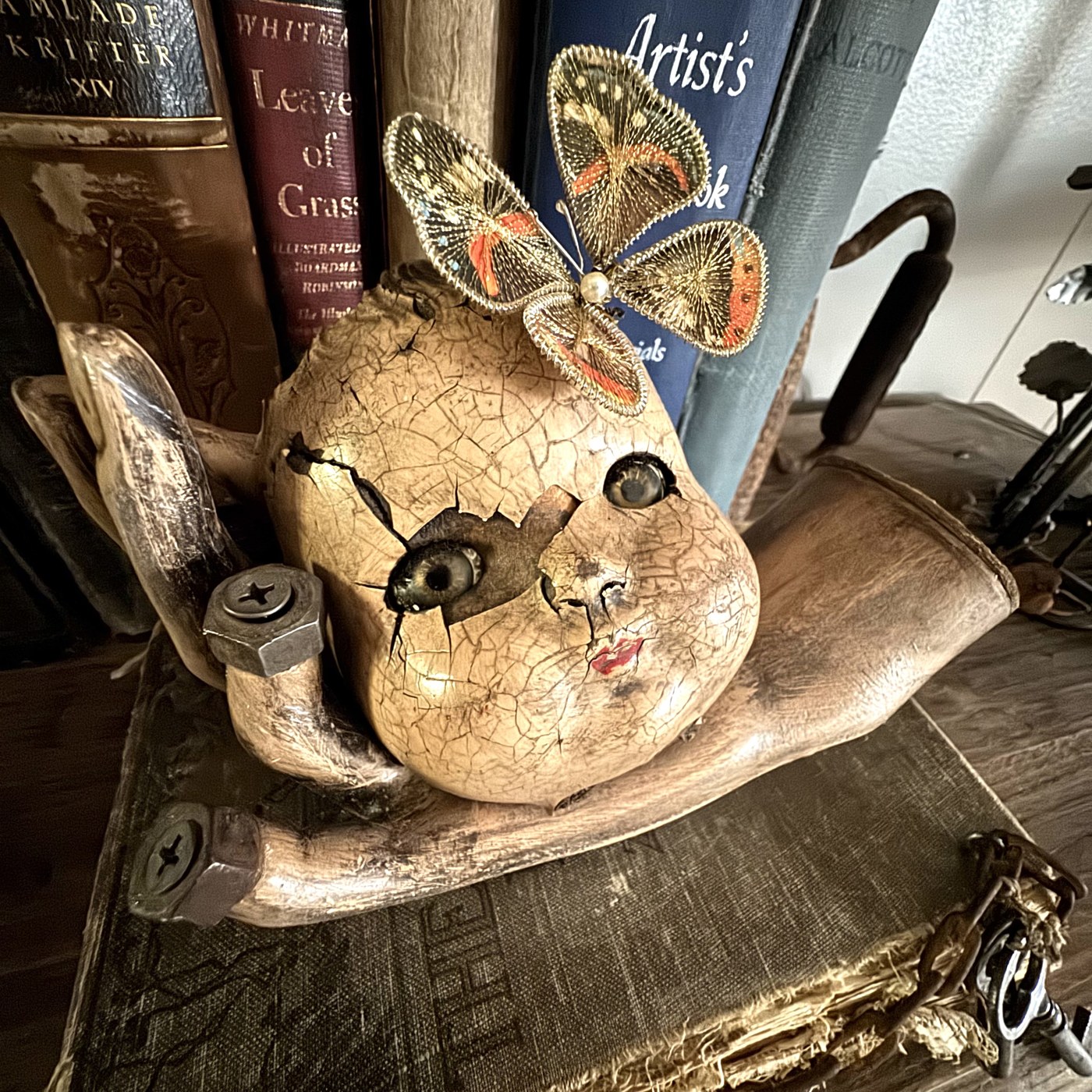 Cracked doll head with butterfly assemblage